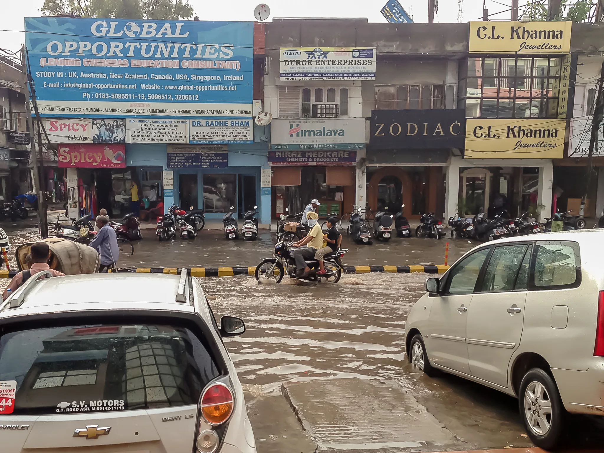 People traverse a flooded street in Amritsar, a city in northwestern India.