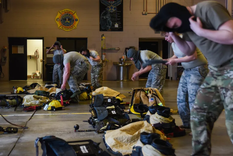 Firefighters practice changing into personal protective equipment (PPE) during a bunker drill. 