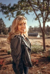 Susan Farren, founder of First Responders Resiliency, Inc., stands in a small field behind a house. 